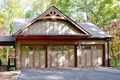 a house with two garages in the front and one on the side, surrounded by trees