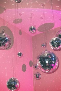 disco balls hanging from the ceiling in a pink room