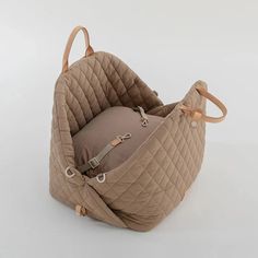 the baby seat is made out of quilted fabric and has handles on each side