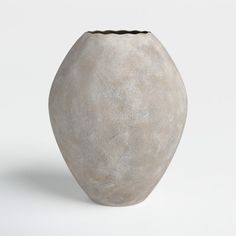 a large gray vase sitting on top of a white table next to a black object