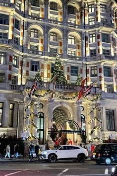 a large building with christmas decorations on it's side and cars parked in front