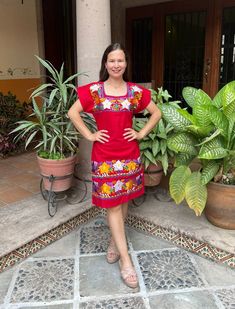 a woman standing in front of some potted plants