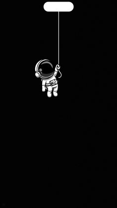 an astronaut floating in the dark holding onto a string with a sign hanging from it's side