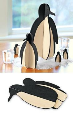 a group of penguins sitting on top of a wooden table