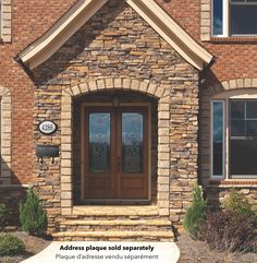 the front entrance to a brick home with double doors