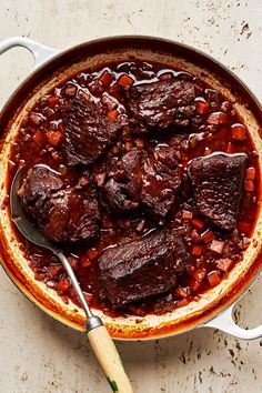 a pot filled with meat and beans on top of a table