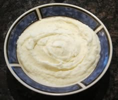 a blue and white bowl filled with mashed potatoes