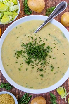 a white bowl filled with soup surrounded by vegetables