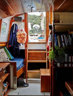 the inside of a boat with stairs leading up to it's second floor and bookshelves