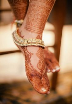 a woman's feet with hennap and bracelets