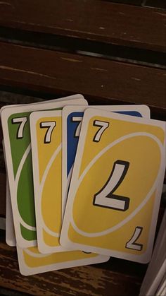 four playing cards sitting on top of a wooden bench