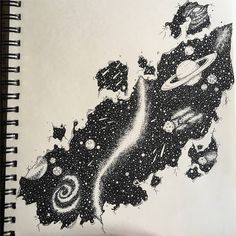 a spiral notebook with black and white ink on it, featuring space images in the background