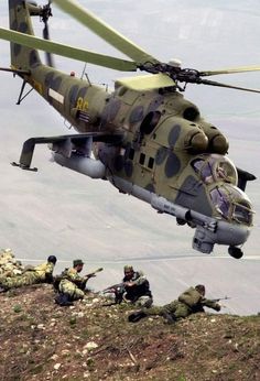 a helicopter flying over some soldiers on the ground