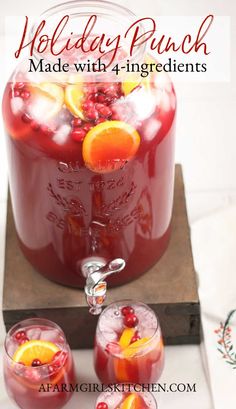 two glasses filled with cranberry punch and garnished with orange slices