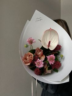 a woman holding a bouquet of flowers on top of a white plate with writing on it