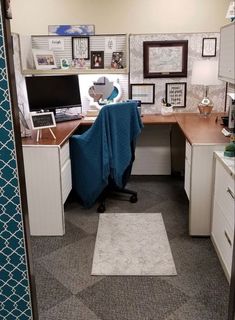 an office cubicle with a desk and chair covered by a blue blanket in the corner