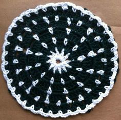 a black and white crocheted doily on top of a brown cardboard box