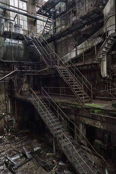 an old factory with stairs leading up to the ceiling and windows on each side of the building