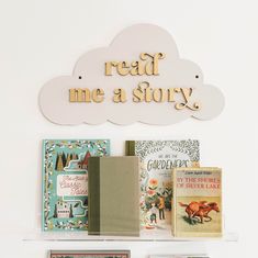 there is a shelf with books on it and a sign above it that says read me a story