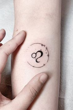 a person with a small tattoo on their arm holding onto the wrist, and her hand is