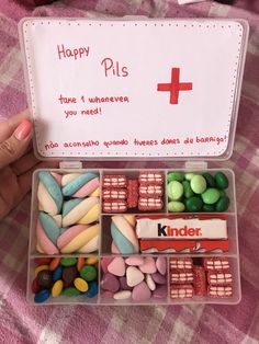 a container filled with lots of candy on top of a pink checkered table cloth