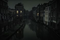 a dark street with buildings on both sides and water in the middle