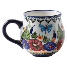 a blue and white coffee cup with colorful flowers on the outside, sitting in front of a white background