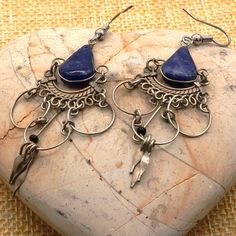 Add a touch of bohemian elegance to your outfit with these vintage Alpaca Peruvian Style Lapis Lazuli Teardrop Tribal Drop Hoop Earrings. The intricate design features a teardrop-shaped lapis lazuli stone, set in a tension style along with black onyx beads. These artisan earrings are with a hook closure for easy wear.  These statement earrings with a chandalier-like design are perfect for ethnic and cultural celebrations, as well as for adding a touch of personality to your everyday style. Excellent vintage condition and ready to wear. Drop length:  72.85 mm Length and width:  63.84 mm x 26.71 mm Lapis Lazuli:  15.68 mm x 9.32 x 3.97 mm Blue Bohemian Metal Hoop Earrings, Bohemian Wire Wrapped Chandelier Earrings For Festivals, Adjustable Bohemian Metal Chandelier Earrings, Adjustable Metal Bohemian Chandelier Earrings, Bohemian Adjustable Chandelier Earrings, Adjustable Bohemian Chandelier Earrings, Bohemian Wire Wrapped Earrings For Festivals, Peruvian Style, Drop Hoop Earrings