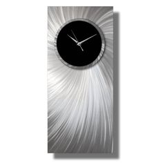 a clock that is on the side of a white wall with silver and black accents