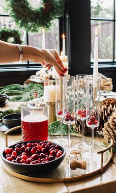 a table topped with lots of glasses filled with liquid next to wine bottles and candles