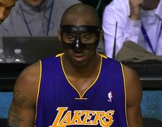 a man with a mask on his face in front of a crowd at a basketball game