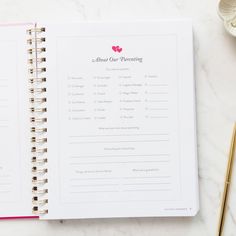 an open planner book on top of a marble table next to a cup of coffee