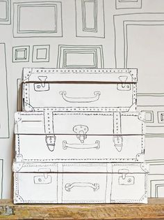 three suitcases stacked on top of each other in front of a wallpapered background