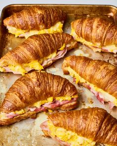 several croissants with ham and cheese on them