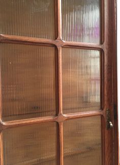 an open wooden door with glass panels on it