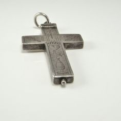 a silver cross on a white surface