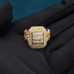 a yellow gold and diamond ring sitting on top of a black jacket