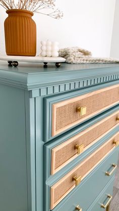 a blue dresser with gold handles and drawers