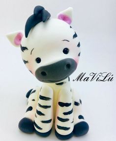 a small toy zebra sitting on top of a white table next to the word mah lii