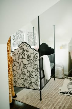 a giraffe standing next to a bed in a bedroom