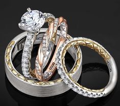 three different colored gold and silver rings with diamonds on them, all stacked up together