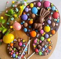 there is a chocolate cake with candy on it and some lollipops in the background