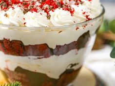 a dessert with white frosting and red sprinkles in a glass dish