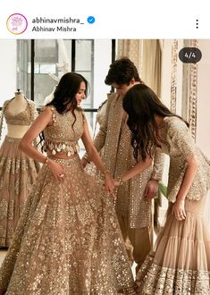 two women in gold dresses looking at each other