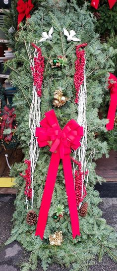 a christmas tree decorated with red bows and ornaments