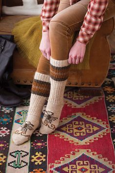 Worked seamlessly from cuff to toe, a pair of boot socks sport an interpretation of the “Phoenix Rising” motif at the instep. The striping at the top of the cuff calls out the motif’s colors. Brown Sheep’s wool/mohair Lamb’s Pride Worsted offers plenty of warmth; the slip-stitch reinforced heel flap will help to keep the socks sturdy season after season. Single ribbing worked throughout the leg creates a snug fit. Ankle Warmers, Brown Sheep, Socks Knitting, Phoenix Rising, Vogue Knitting, Knitting Magazine, Late Winter, Colors Brown, Sock Patterns