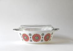 a glass bowl with red and green designs on it sitting on a white tablecloth