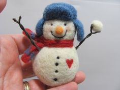 a small snowman with a blue hat and red scarf