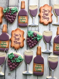 decorated cookies with wine and grapes are arranged on a table