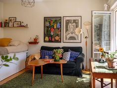 a living room filled with furniture next to a bed and a table in front of a window